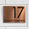 Brushed copper metallic house sign mounted beside a front door